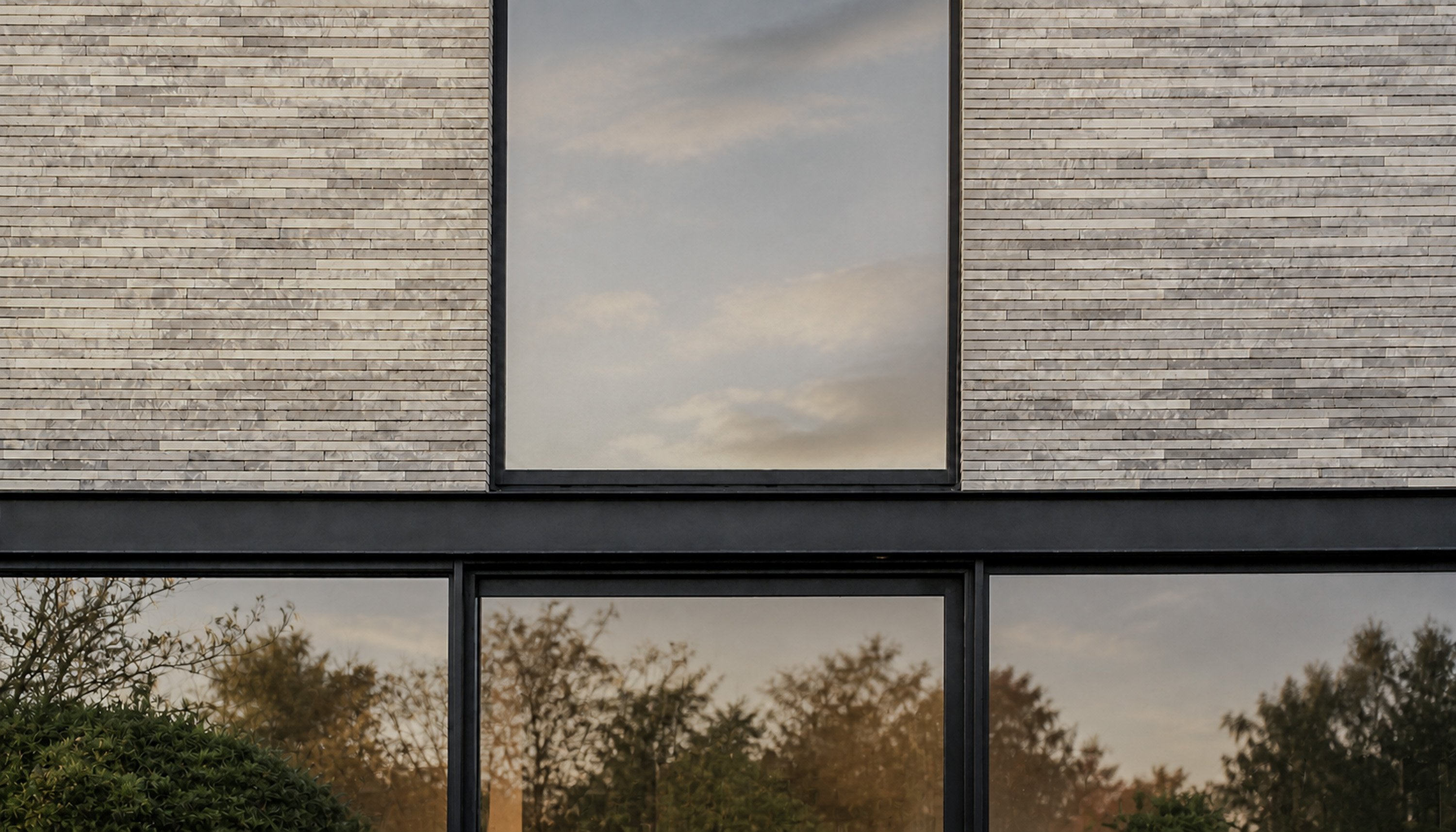 Geveldetail met lichte baksteen, donkere lijnen en schrijnwerk